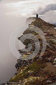 Hiking on famous Romsdalseggen Ridge in fog, Andalsnes, Norway