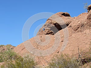 Man hiking on the Hole-In-The-Rock formation in Arizona