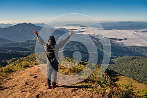 Man hiking raise hand enjoy succeed and looking at mountain range