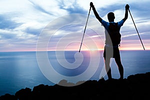 Man hiking silhouette in mountains, ocean and sunset