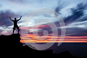 Man hiking silhouette in mountains, ocean and sunset