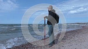 Man with hiking sticks at beach near sea