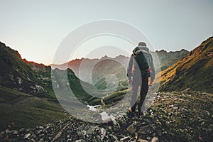 Man hiking at sunset mountains with heavy backpack photo