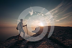 Man hiking at sunset mountains with heavy backpack