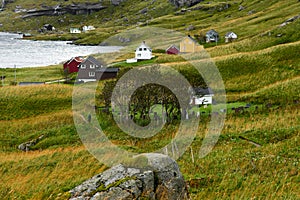 Man hiking to the village VInstad next to a graveyard on Lofoten Islands in Norway.