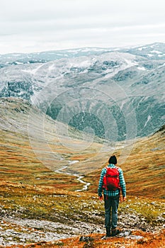 Man hiking trek in mountains with backpack