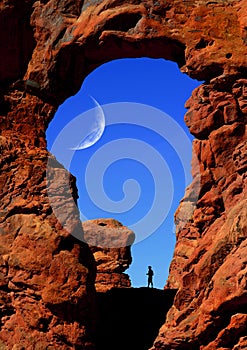 Man Hiking Under Arch with Moon