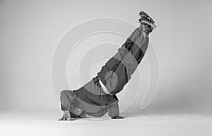 A man hip hop dancer or bboy freezes in one pose on a white background. Bboy doing stylish stunts.