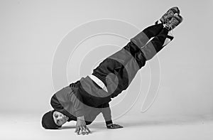 A man hip hop dancer or bboy freezes in one pose on a white background. Bboy doing stylish stunts.