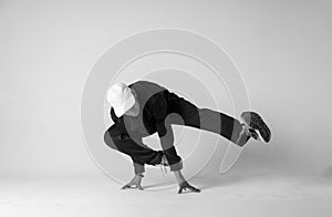 A man hip hop dancer or bboy freezes in one pose on a white background. Bboy doing stylish stunts.