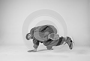 A man hip hop dancer or bboy freezes in one pose on a white background. Bboy doing stylish stunts.