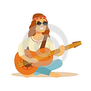 Man Hippie Dressed In Classic Woodstock Sixties Hippy Subculture Clothes Sitting Playing Guitar In Round Shades