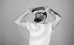 Man with hipster beard enjoying digital tech novelty. Excited bearded man watching movie in VR glasses, 3D experience