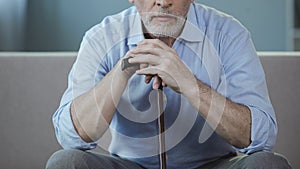 Man in his 50s sitting on sofa and thinking about his life, loneliness period