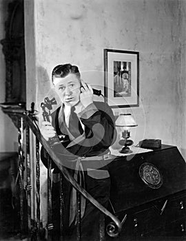 Man in his apartment listening on his telephone