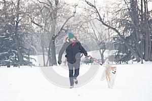 Man and his beautiful dog akita walking on snow. Winter concept