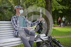 Man with his bicycle resting in a city park