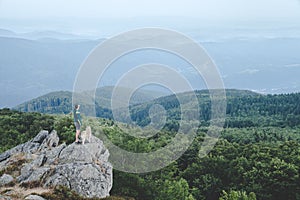 Man with his dog at the top of a mountain having a beautiful view