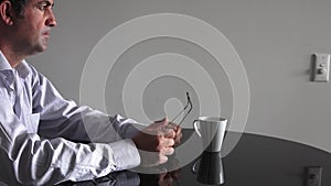 Man in his forties (40s) sitting at a table upset.