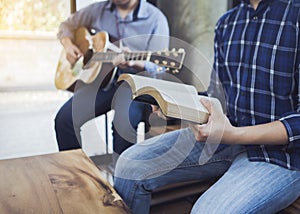 a man and his friend sing a song from hymn book