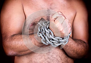 Man with his hands chained with chains and a padlock