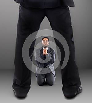 Man on his knees praying not to be dismissed