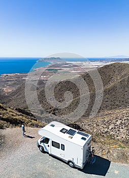 Man by his motor home looking nice views from top of the mountain photo