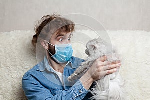 A man with his pet is sitting on a sofa at home. Quarantine coronavirus