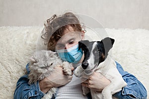 A man with his pet is sitting on a sofa at home. Quarantine coronavirus