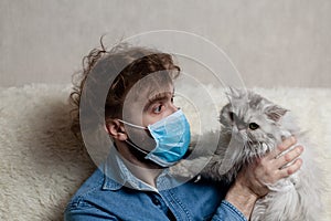 A man with his pet is sitting on a sofa at home. Quarantine coronavirus