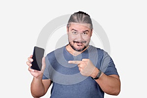 A man in his 30s endorsing a smartphone. Pointing to the cellphone with his index finger. Advertising an app photo