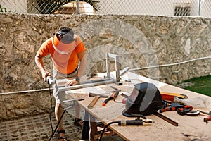 A man in his yard is engaged in locksmith work. Hobby, in a home workshop.