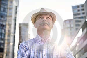 Man in hispanic hat with mustache looking at camera smiling in city