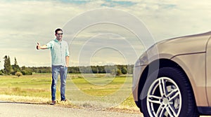 Man hitchhiking and stopping car at countryside