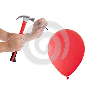 Man hitting a nail into a red balloon