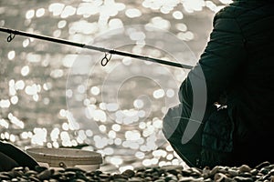 Man hobby fishing on sea tightens a fishing line reel of fish. Calm surface sea. Close-up of a fisherman hands twist