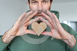 Man hold abstract love symbol. 3d decorative object made of recycled cardboard paper. An Valentine Holiday concept. eco