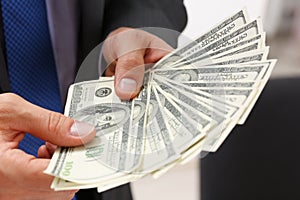 Man hold in arm pack of hundred dollar bills