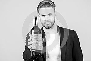 Man hold bottle of wine, alcohol. Macho with bottle, bad habits. Sommelier or degustator with wine, winery. Alcohol