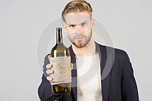 Man hold bottle of wine, alcohol. Macho with bottle, bad habits. Sommelier or degustator with wine, winery. Alcohol addiction, bad