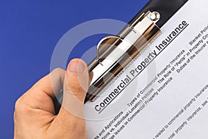 Man hold commercial property insurance claim form and policy in hand. Company real estate contract concept. Blue