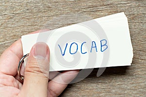 Man hold the flash card with handwriting word vocab