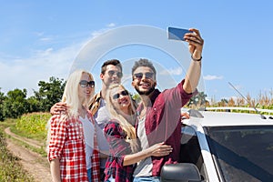 Man hold smart phone camera taking selfie photo friends smile countryside car