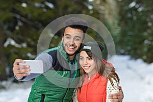 Man Hold Smart Phone Camera Taking Selfie Photo Snow Forest Young Mix Race Couple Outdoor Winter