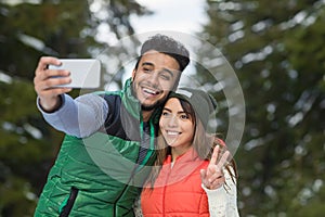 Man Hold Smart Phone Camera Taking Selfie Photo Snow Forest Young Mix Race Couple Outdoor Winter