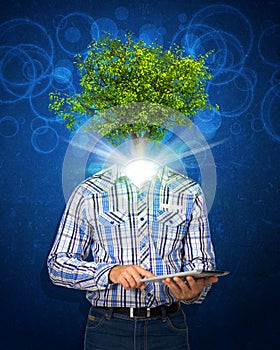 Man hold tablet pc. Green tree instead his head