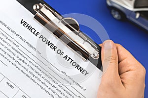 Man hold vechile power of attorney application form. Office desk and clipboard with agreement. Top view photo