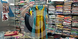 man holded girls fashion party item at garment store in India