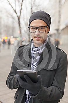 Man holdin i-pad tablet computer on street