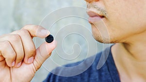 Man holding an activated charcoal pills